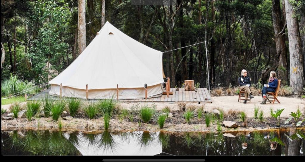 bell tent by pond with a backdrop of trees