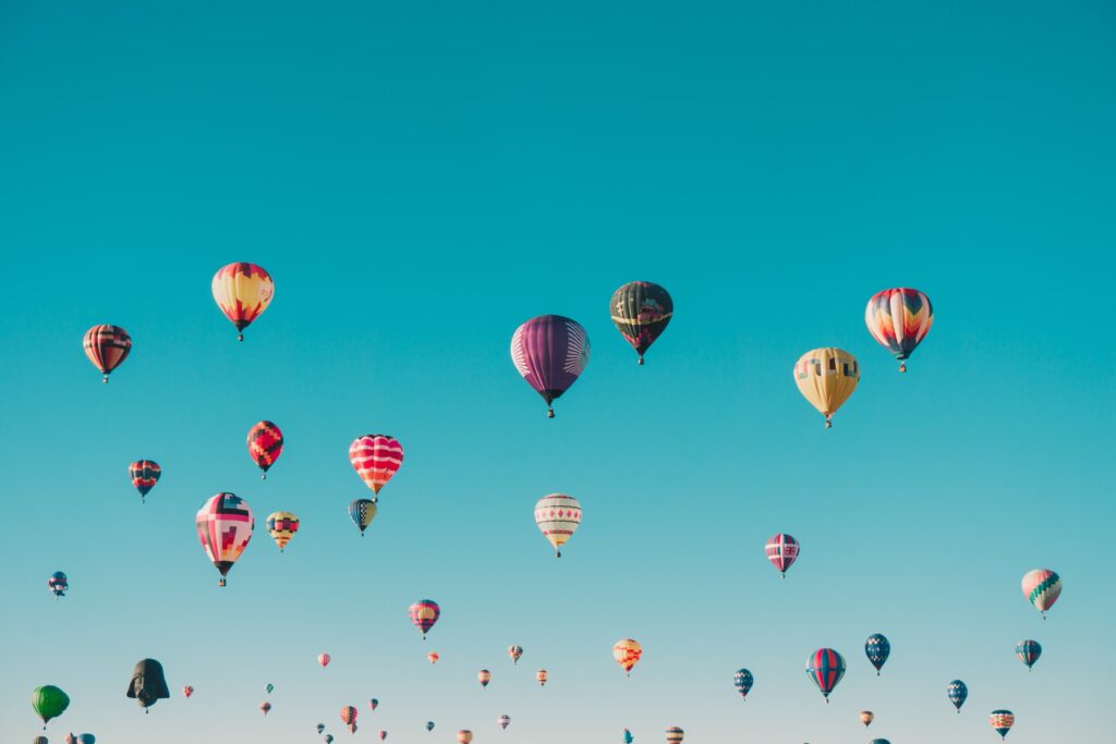 colourful hot air balloons against a pale blue sky